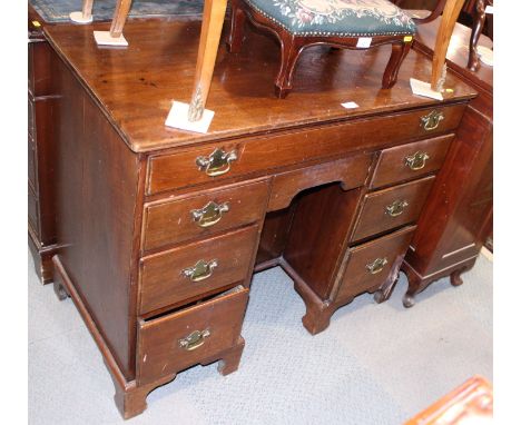 A Georgian mahogany kneehole desk fitted cupboard and 7 drawers on bracket feet.