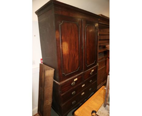 A late Georgian linen press, the upper section enclosed two flame figured panelled doors, fitted one tray over two short and 