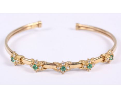 A 9ct gold and emerald bangle set brilliant accents