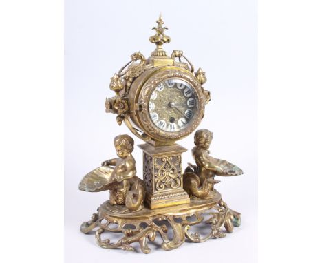 A late 19th century brass mantel clock, flanked cherubs holding shells, 12" high