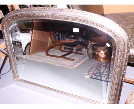 A carved silvered frame overmantel mirror with bevelled glass, 42 1/2" wide