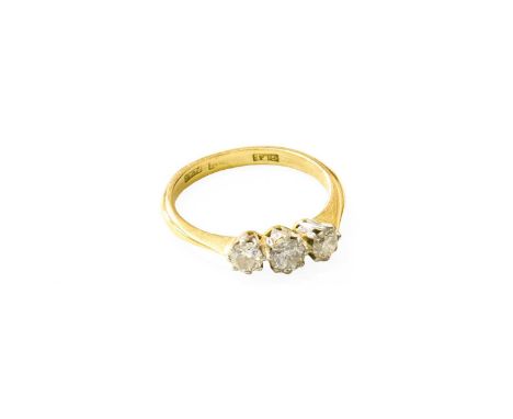 A Diamond Three Stone Ring, the graduated round brilliant cut diamonds in white claw settings, to a yellow tapered shoulder p