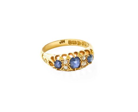 An 18 Carat Gold Sapphire and Diamond Ring, three oval cut sapphires, spaced by pairs of old cut diamonds, in yellow claw set