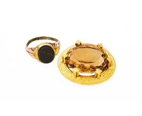 A 15 Carat Gold Citrine Brooch, the oval cut citrine in yellow quatrefoil design claw settings, to a frame with engraved deco