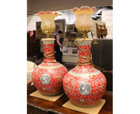 A Large Pair of Modern Chinese Porcelain Bottle Vases, red ground, enamelled with lotus scrolls, having roundels containing c