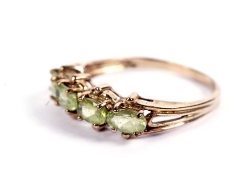 A four-stone peridot ring, in 9ct yellow gold mount and shank, ring size P, 1.9g gross.