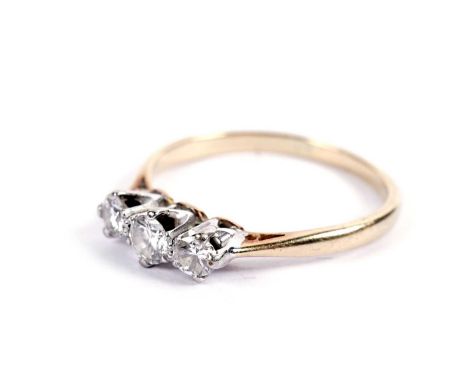 A diamond three-stone ring, the round brilliant-cut diamonds crown set on a gold shank, size N, 2.4g gross.