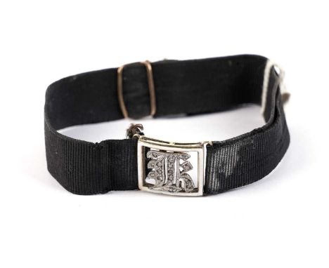 A Victorian diamond and white enamel initial bracelet, gothis 'K', on black ribbon.
