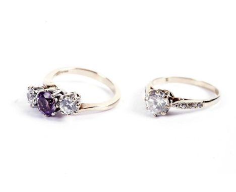 An amethyst and white three-stone ring, on a 9ct gold shank, size M, 3.5g gross; and a white-stone solitaire ring, on a 9ct g