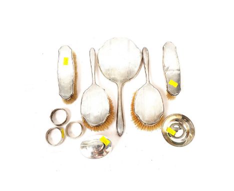 A silver backed dressing table set by Walker and Hall, Sheffield, comprising: hand mirror, hand brushes, and clothes brushes;
