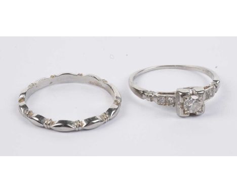 A diamond solitaire ring, in white gold, stamped "18K Fidelity", size K 1/2; and a shaped white gold wedding band, stamped "1