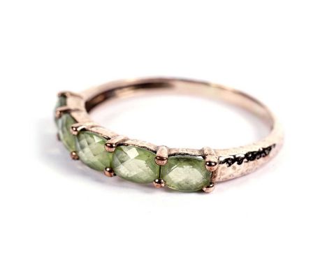 A five-stone peridot ring, in 9ct yellow gold mount and hammered shank, ring size X, 2.7g gross.