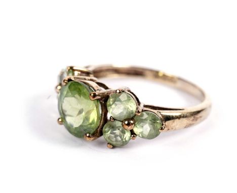 A seven-stone peridot dress ring, in 9ct yellow gold mount and shank, ring size P, 3.0g gross.