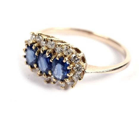 A sapphire and diamond cluster ring, with three oval-cut sapphires surrounded by a frame of round brilliant-cut diamonds, on 