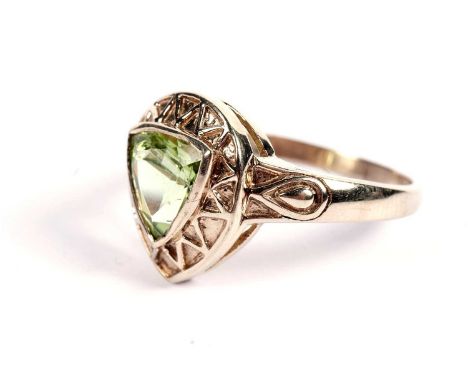 A peridot dress ring, trilliant cut, and rub set within a curvilinear bezel, on a 9ct gold shank, 3.5g gross, size Q.