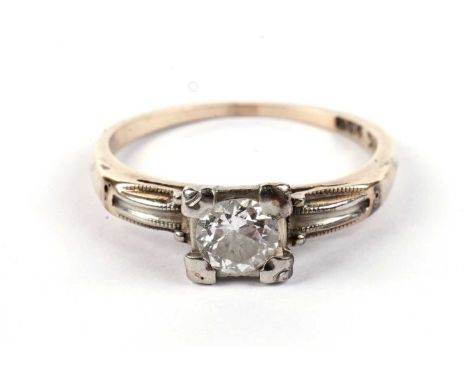 A diamond solitaire ring, with white gold setting and yellow gold shank, stamped "14K", size J, 1.5g gross.