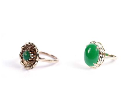 A jadeite cabochon dress ring, in yellow gold, stamped "14K 585", size S, 4.0g; and a green stone flower motif dress ring, in