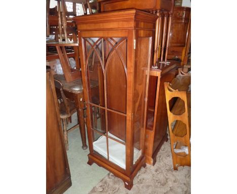 A small reproduction yew wood veneered display cabinet in the Georgian style enclosed by a full length glazed panelled door w