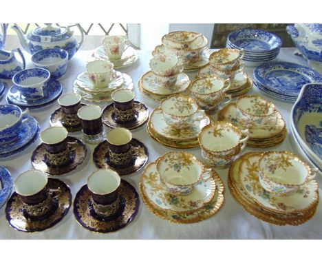 A collection of early 20th century Coalport coffee wares with gilt finish on a dark blue ground with pierced silver mounts of