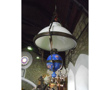 A ceiling hanging lamp, stylised as an oil lamp with blue grounded ceramic font with symmetrical foliate decoration set withi
