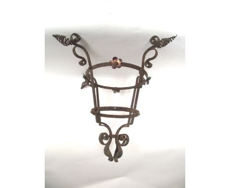 An antique iron work ceiling light/lantern cradle loosely in the Art & Crafts manner with scrolling framework, highlighted wi