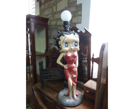 A floor standing lamp in the form of a cast iron street lantern post with opaque bulb and standing moulded figure in the form