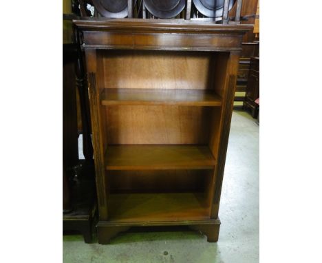 A small reproduction yew wood veneered freestanding open bookcase in the Georgian style with two adjustable shelves, raised o