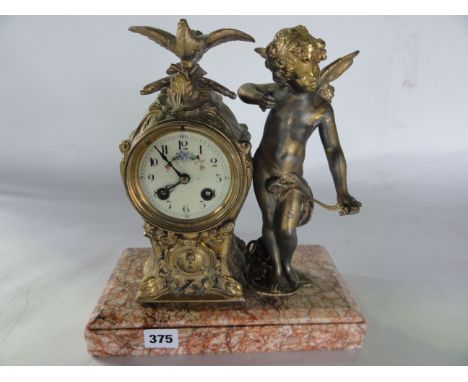 A 19th century French mantle clock set on a marble base, the clock case in gilded spelter with cupid to the side