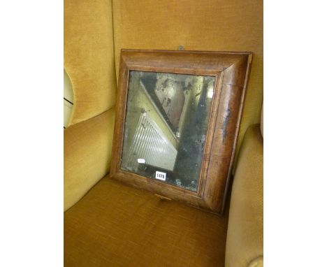An 18th century walnut cushion moulded wall mirror of rectangular form enclosing a bevelled edge mirror plate, 46 cm max