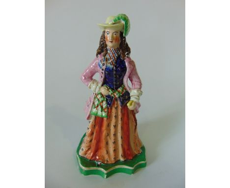 An unusual 19th century Staffordshire theatrical figure of a pink jacketed female character in hat with green feather with bl