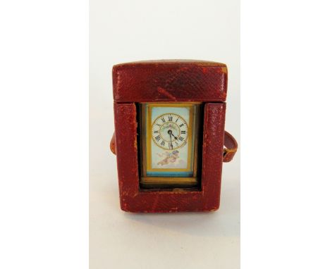 A miniature 19th century carriage clock with hand painted porcelain dial showing floral swag, cherub, etc with 8 day timepiec