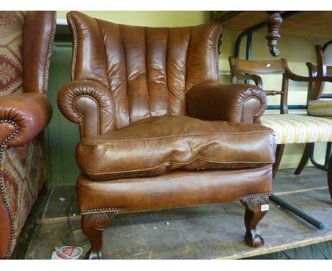 A good quality contemporary wing chair with tan coloured leather upholstery, the shaped back over scrolled arms and with loos
