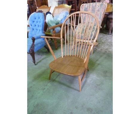 An Ercol light elm and beechwood low hoop and stick back armchair with blue and gold printed label 