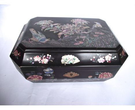 A late 19th/early 20th century oriental lacquer work jewellery box of rectangular form with canted corners, the exterior heav