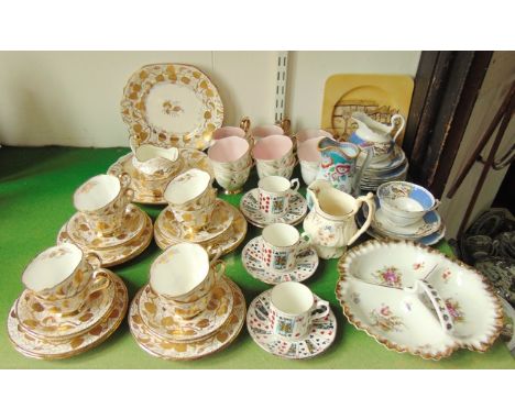 A collection of New Chelsea Staffordshire teawares with gilt rose leaf and pink painted rosebud detail comprising a pair of c