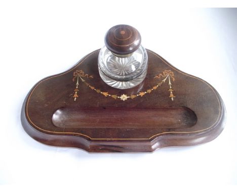 An Edwardian mahogany desk standish with stained and other inlay detail of trailing foliate garland, ribbons, etc with a stri