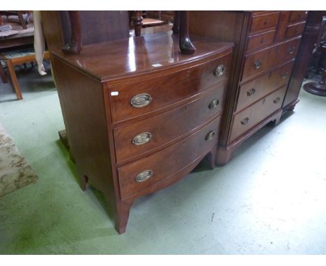 A small 19th century mahogany bow fronted bedroom chest of three long graduated drawers with well matched flame veneers over 