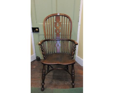 A 19th century Windsor elm back elbow chair with comb seat, with shaped and pierced centre splat, turned supports and crinoli