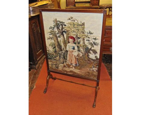 A Victorian mahogany framed fire screen raised on lions paw feet, the rectangular frame incorporating a handworked tapestry p