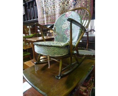 An Ercol stained elm and beechwood low hoop and stick back rocking chair with open swept arms