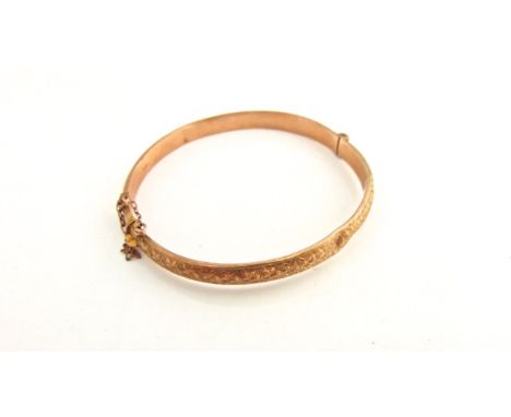 A 9ct rose gold hinged bangle, engraved leaf details, 6.6g