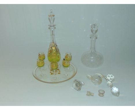 A liquor set comprising slender footed decanter and five matching glasses, all with green tinted bowls with gilded ivy and ot