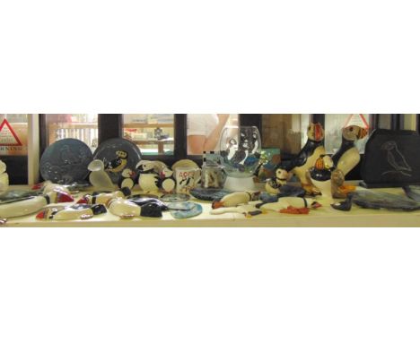 A collection of  ceramics and other items all on the puffin theme and including five pottery wall plaques, an Edgecombe Potte