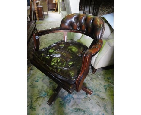 A reproduction swivel office desk chair with soft brown leather buttoned loose seat cushion, with buttoned back and arm rests