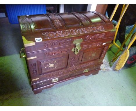A small hardwood domed top chest with carved foliate and inlaid brass detail, side carrying handles, two small drawers and br