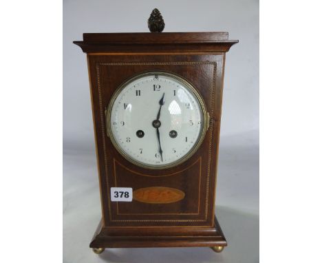 An Edwardian mahogany mantle clock with inlaid case and the 8 day movement behind a convex dial
