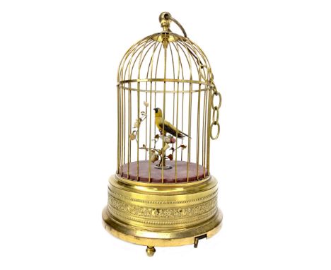 EARLY 20TH CENTURY BIRD AUTOMATON, modelled perching, with surrounding foliage, contained in a gilded cage, movement and chir