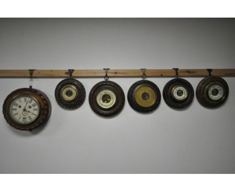 A CARVED WOOD CIRCULAR WALL CLOCK, the glazed door enclosing an enamel dial, diameter 24cm and five late 19th/early 20th cent