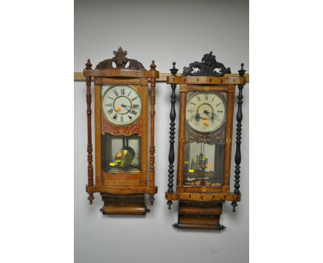 TWO LATE 19TH CENTURY AMERICAN WALNUT AND INALID WALL CLOCKS, with a foliate decorated finial, with turned pillars, both encl