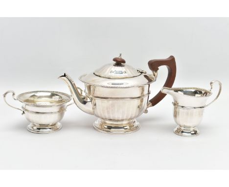 A GEORGE V SILVER THREE PIECE TEA SERVICE OF CIRCULAR PANELLED FORM, reeded rims, S scroll handles, tea pot with brown bakeli